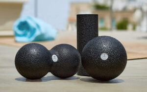 Drei schwarze Gymnastikbälle auf einem Holztisch, Vergleich