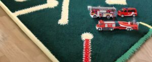 Ein Teppich mit einem Spielzeug-Feuerwehrauto, bekannt als Siku Feuerwehr.