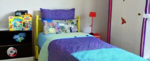Ein Kinderzimmer mit einem blau-lila Bett, das speziell für 5-jährige Kinder entworfen wurde.