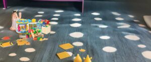 Ein Kind spielt mit einem Spielzeug auf dem Boden.