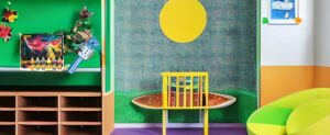 Ein mit Spielzeug gefülltes Kinderzimmer mit bunten Wänden und einem Stuhl, der für Siebenjährige geeignet ist.