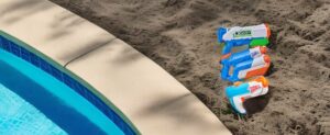 Ein Pool mit einer Flasche Wasserpistolenreiniger auf dem Sand.