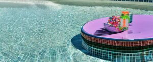 Ein farbenfroher Teller, der auf einem Tisch neben einem mit Wasserbomben gefüllten Pool ruht.